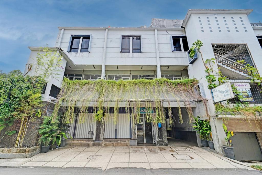 a white building with plants on the front of it at OYO 93328 Graha Citra Syariah in Karajaan