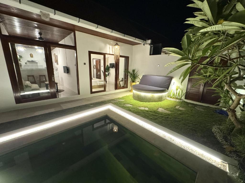 einen Hinterhof mit Pool in der Nacht in der Unterkunft Lovely villa 1 minute from the beach in Canggu
