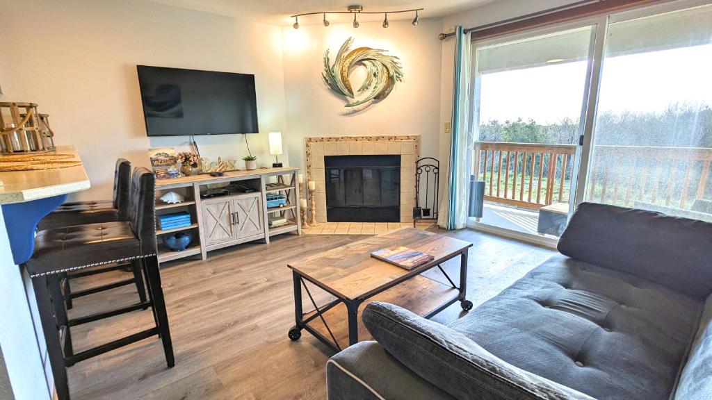 a living room with a couch and a fireplace at Calypso at Nautilus - Pet Friendly, Walk to beach! in Ocean Shores