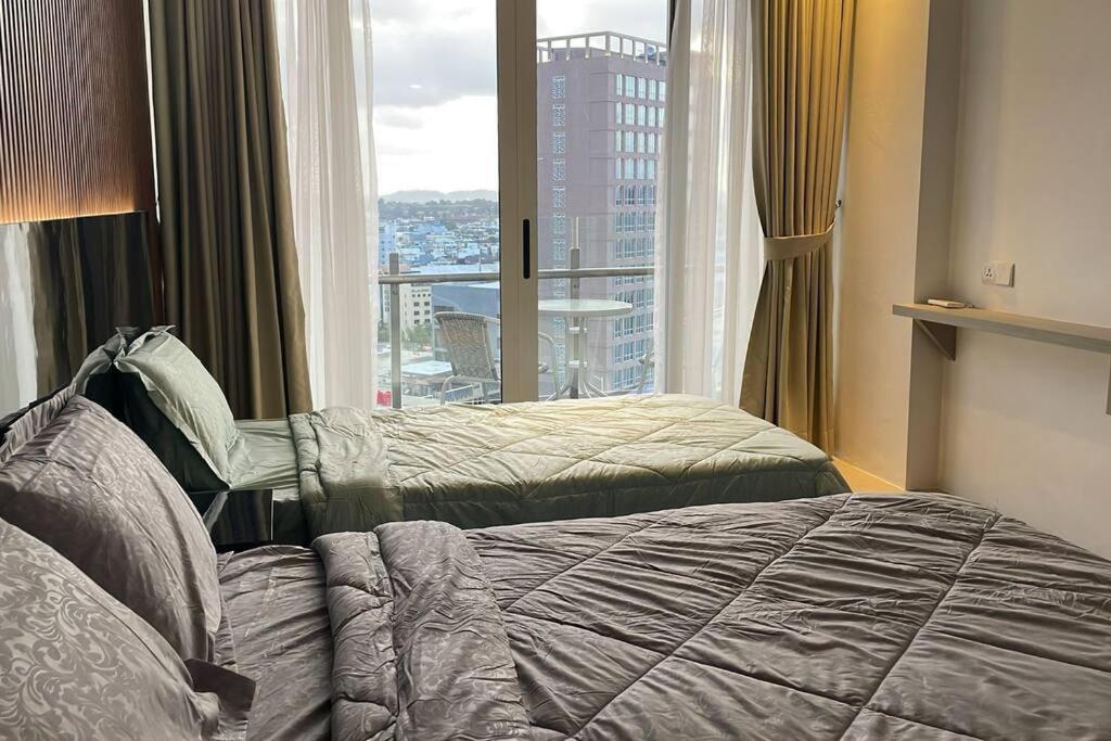 a bedroom with two beds and a large window at Apartemen Nagoya Thamrin Tower B lvl 12 Free Netflix in Nagoya