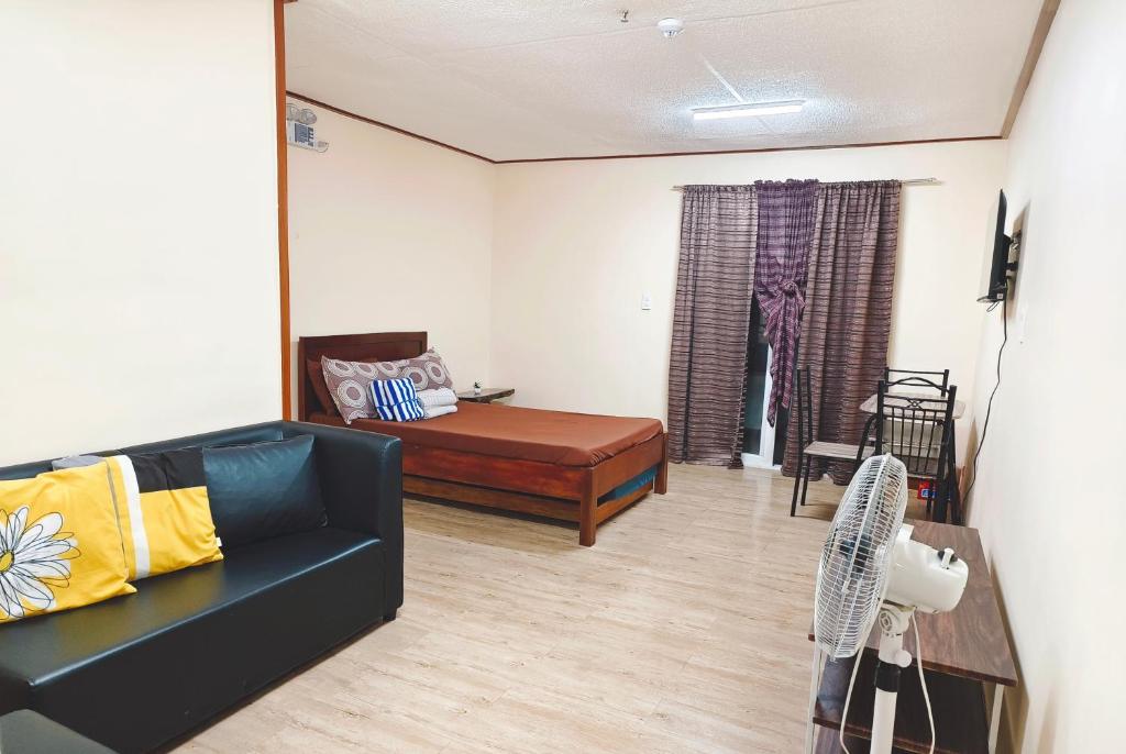 a living room with a bed and a couch at Cozy Condo near Burnham in Baguio