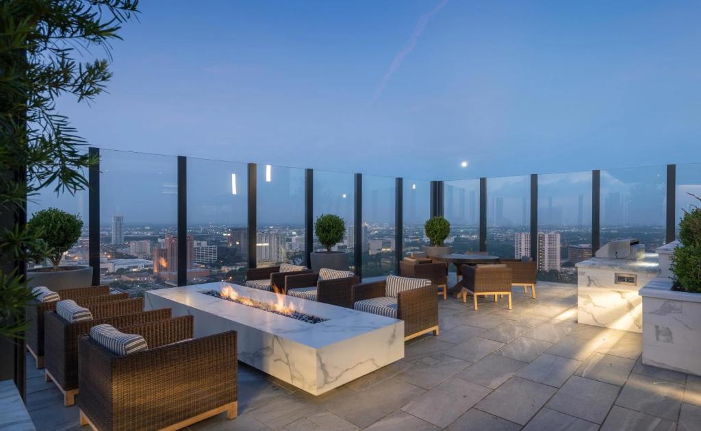a rooftop patio with a fireplace and a view of the city at Hanover BLVD Place in Houston