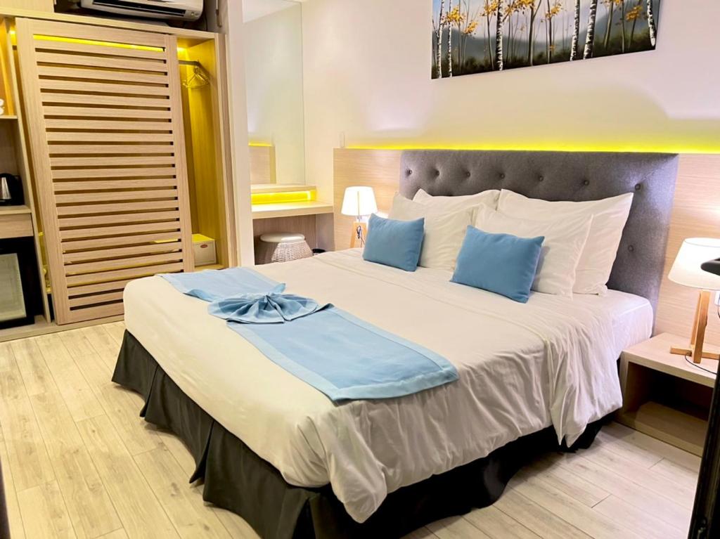 a bedroom with a large bed with blue pillows at Lovely Lady Villa Oceanami Resort, Vung Tau in Long Hai