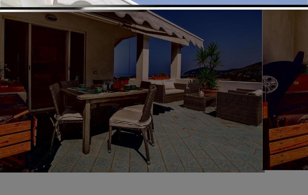 a patio with a table and chairs on a roof at Splendido Appartamento in Santa Maria di Castellabate