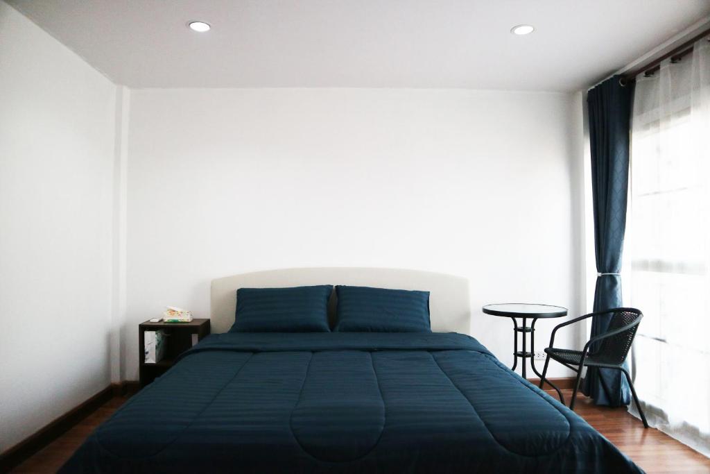 a bedroom with a blue bed and a table at Happyhouse Laksi station (PK14) in Lak Si