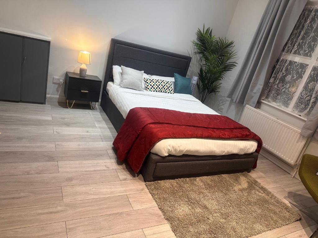 a bedroom with a bed with a red blanket at Paradise Vuze in Tilehurst