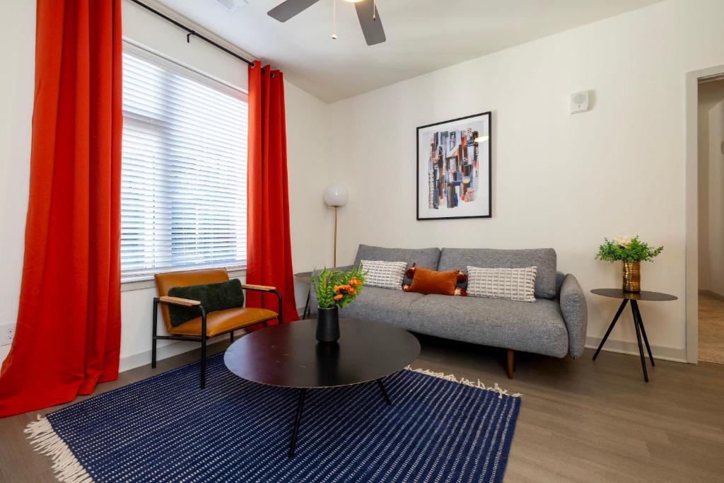 a living room with a couch and a table at TWO Modern Nulu CozySuites in Louisville