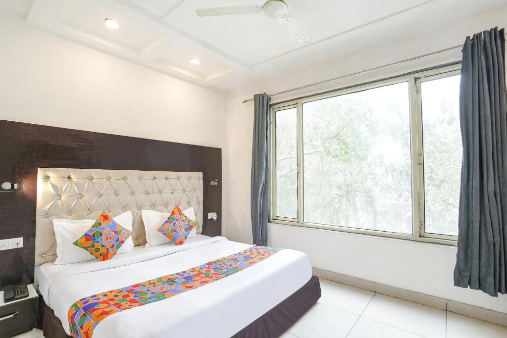 um quarto com uma cama grande e uma janela em FabHotel Madhuban Inn em Rishikesh