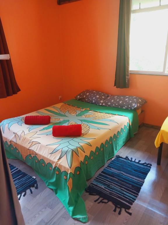 2 camas en una habitación con paredes de color naranja en Papehau Room en Fare