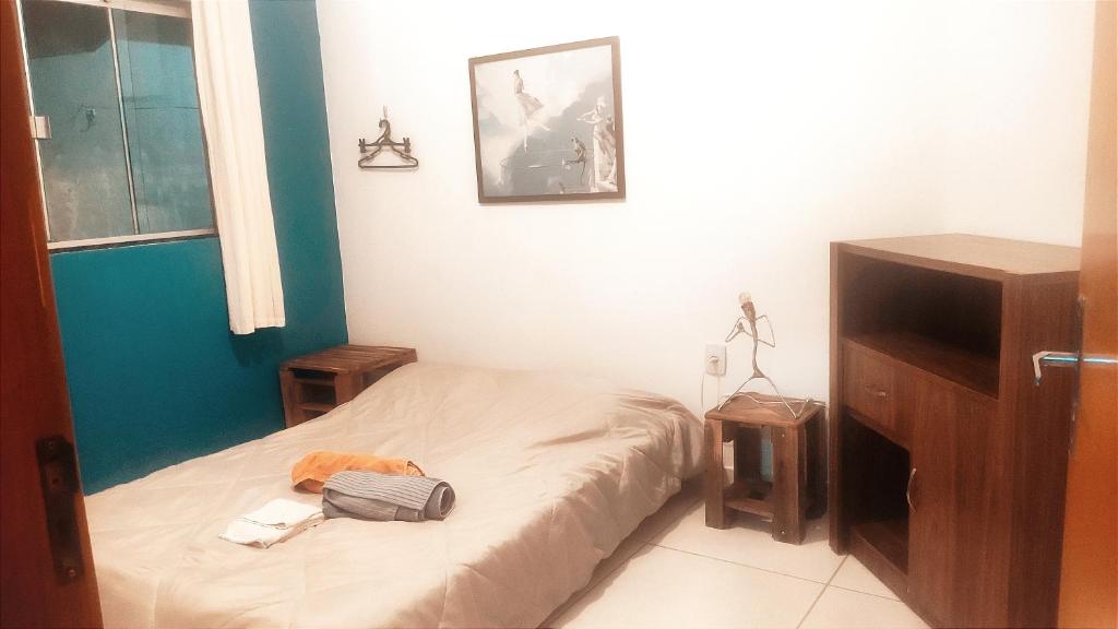 mała sypialnia z łóżkiem i dwoma stołami w obiekcie Quarto Goiânia Jardim Talismãs w mieście Goiânia