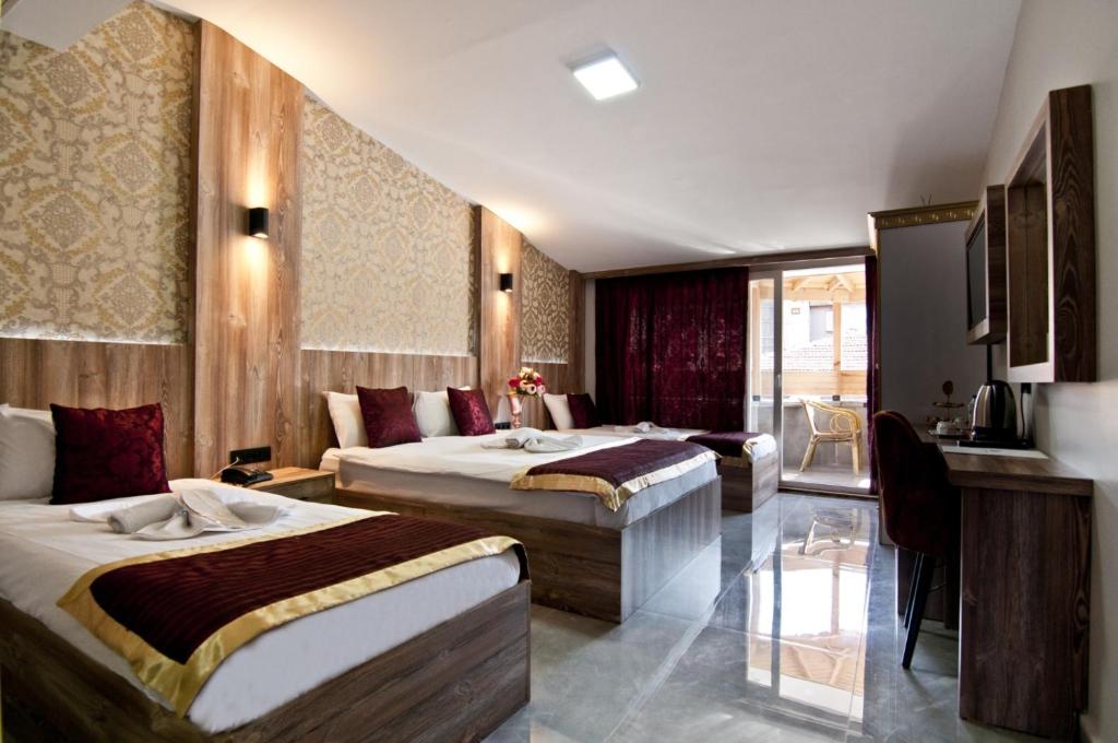 イスタンブールにあるVali Konak Hotelのベッド2台とソファが備わるホテルルームです。