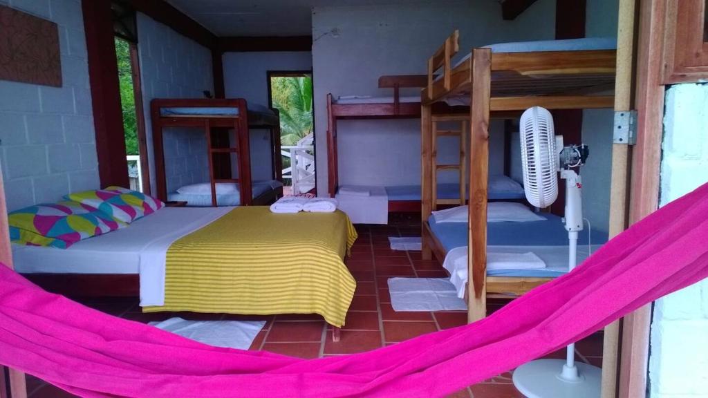 a bedroom with two bunk beds and a pink hammock at Hotel Sol y Luna in Capurganá