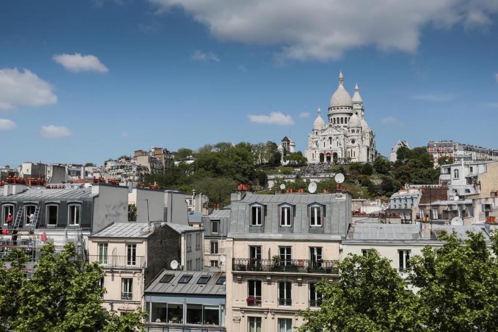 a large building with a clock tower on top at Le Regent Montmartre by Hiphophostels in Paris