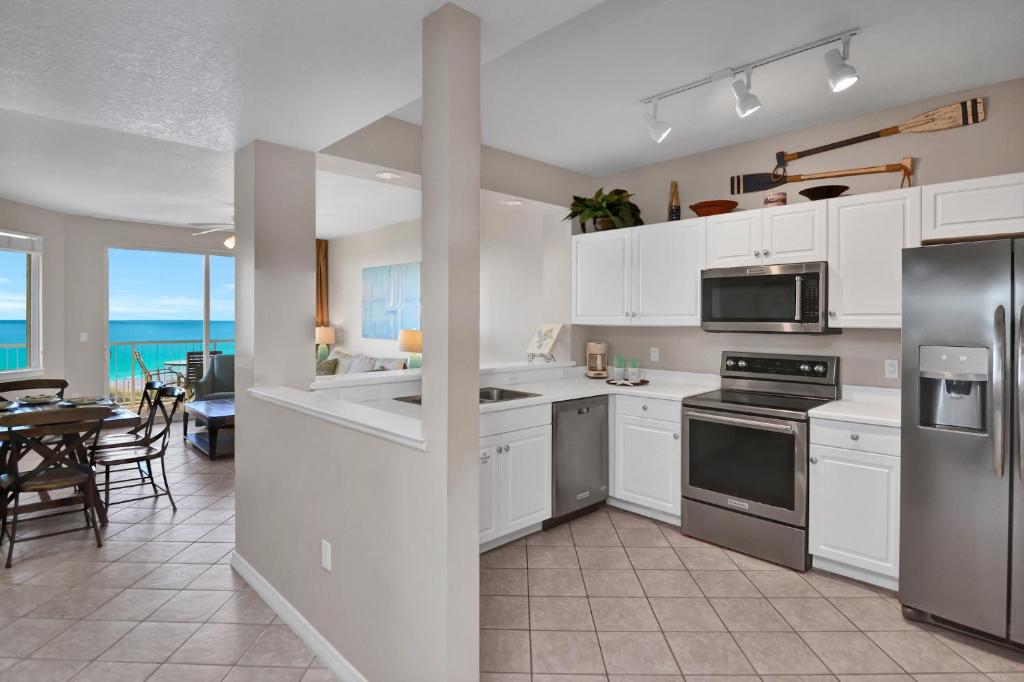 een keuken met witte kasten en een eetkamer bij Destin West Gulfside 301 - True Beachfront Luxury - Beautiful Views! in Fort Walton Beach