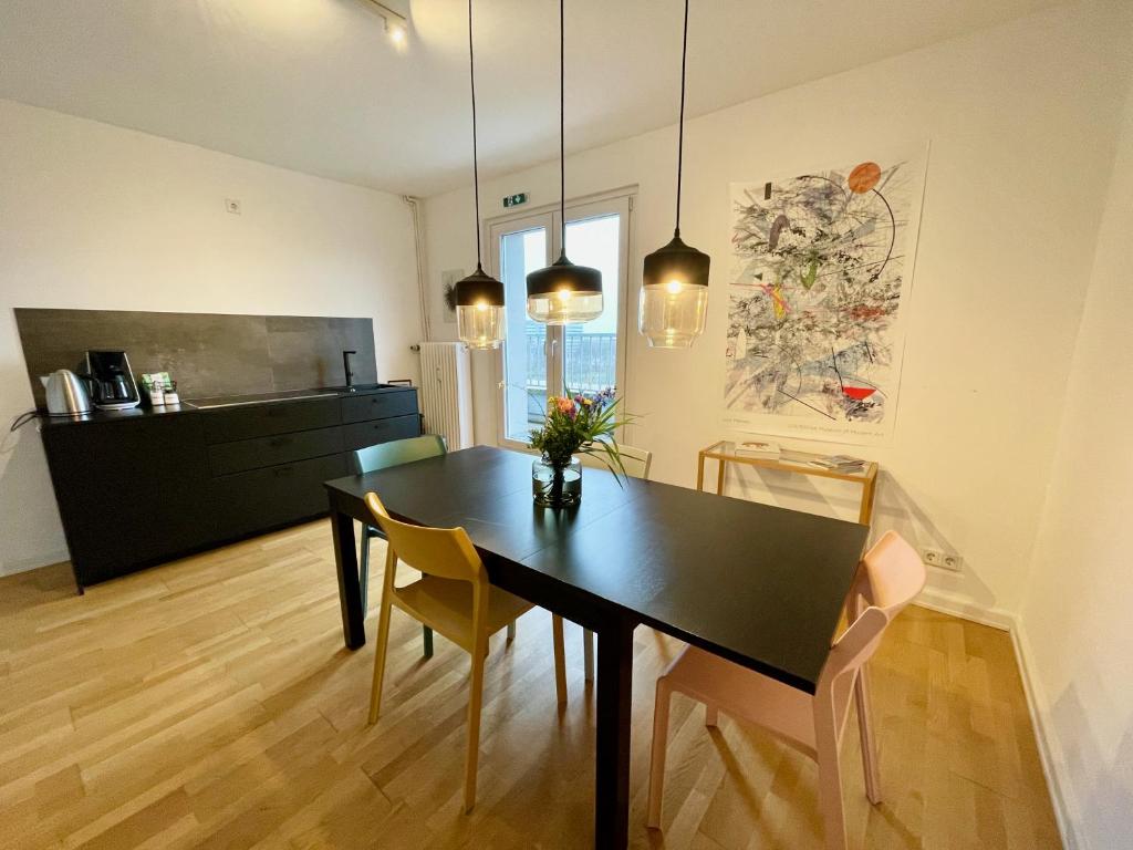 a dining room with a black table and chairs at The Suites City Lofts at the Park in Hamburg