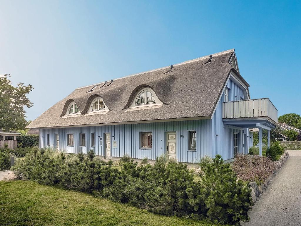 een blauw huis met een gambrel dak bij ReetTraum Prerow in Prerow