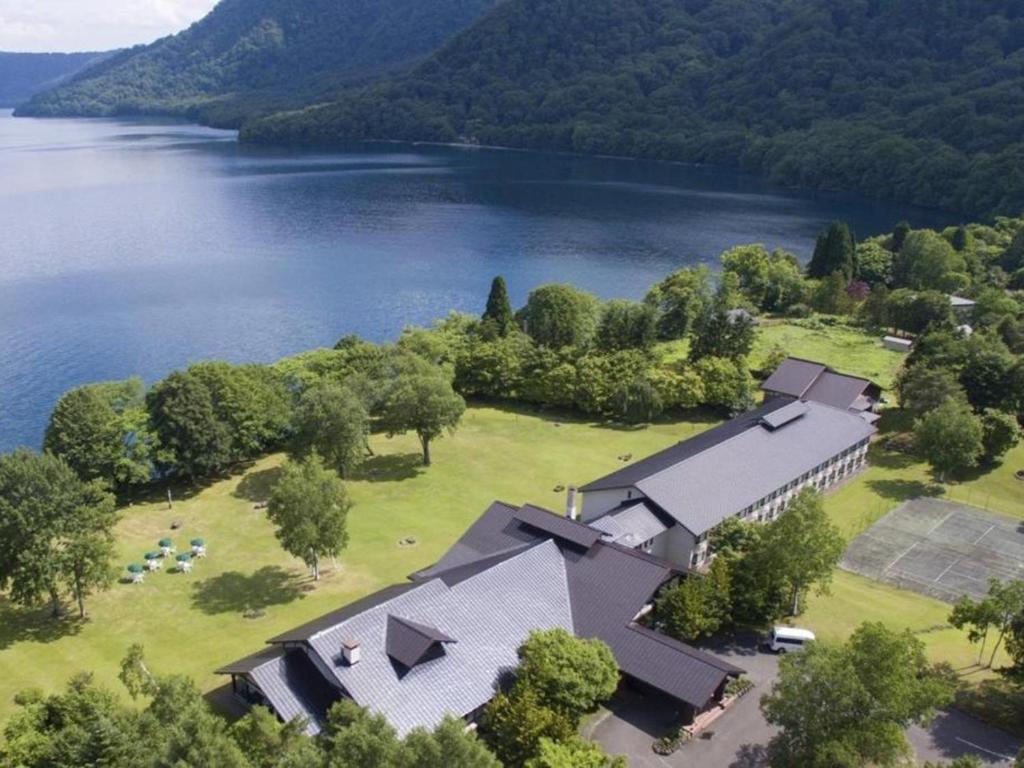 an aerial view of a house next to a lake at Towada Prince Hotel in Kosaka