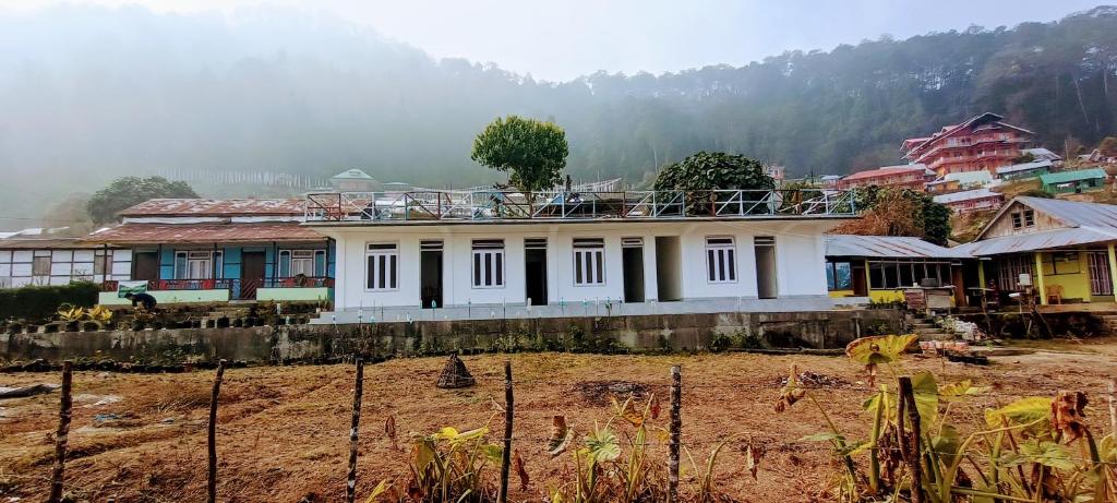 ein Haus in einem Dorf mit einem Berg im Hintergrund in der Unterkunft Crystal Cottage in Pedong