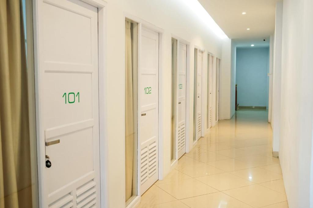 a corridor with white closets in a building at Kareem Syariah Hostel Bukittinggi in Bukittinggi