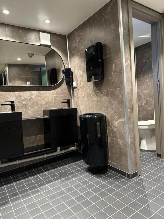 a bathroom with two sinks and a mirror and a toilet at Den Röda Båten in Stockholm