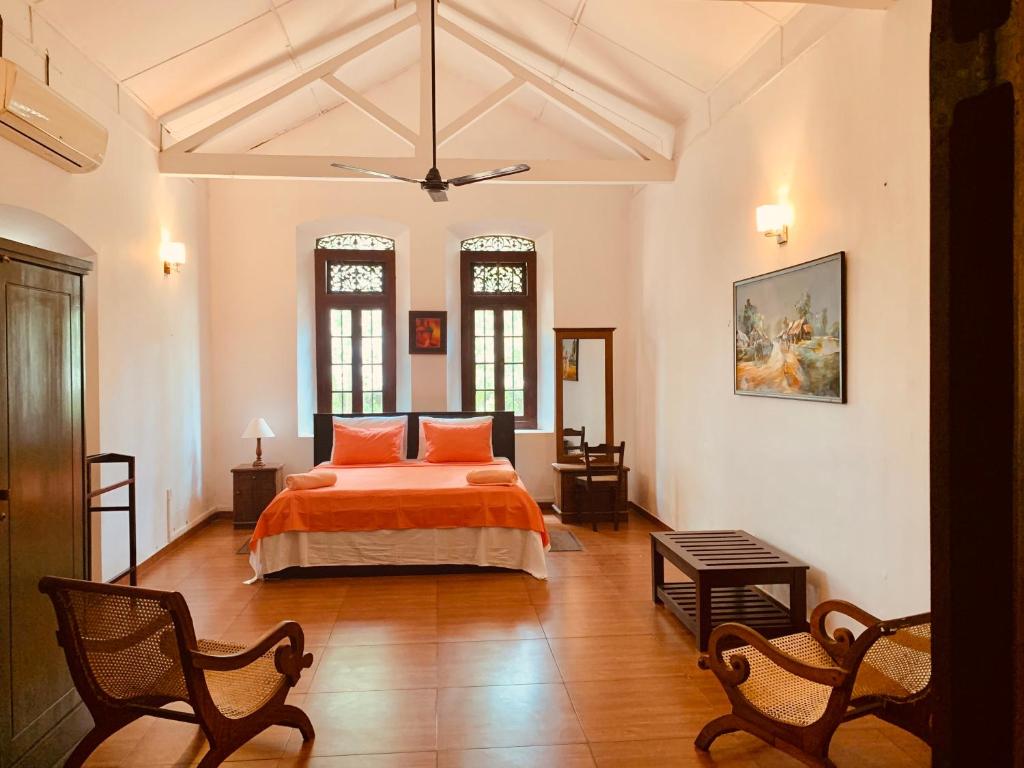 1 dormitorio con 1 cama con almohadas de color naranja en Stuart House Tangalle, en Tangalle