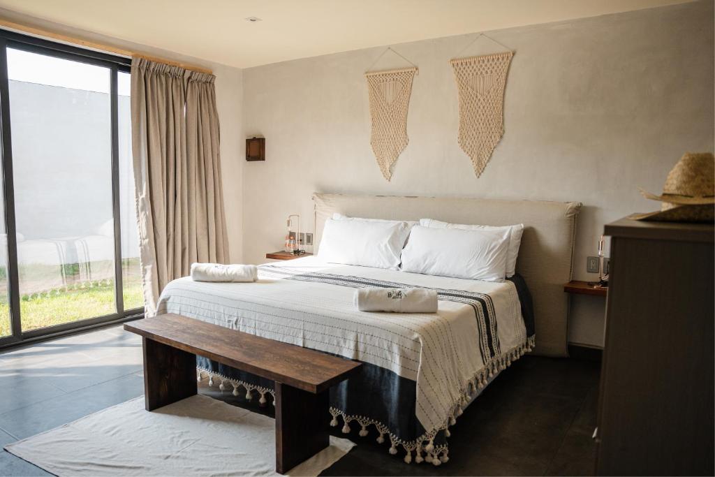 a bedroom with a large bed and a window at Bora Boutique - Adults Only in Puerto Escondido