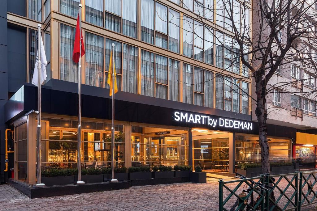 ein Gebäude mit zwei Flaggen davor in der Unterkunft Smart by Dedeman Eskişehir in Eskisehir