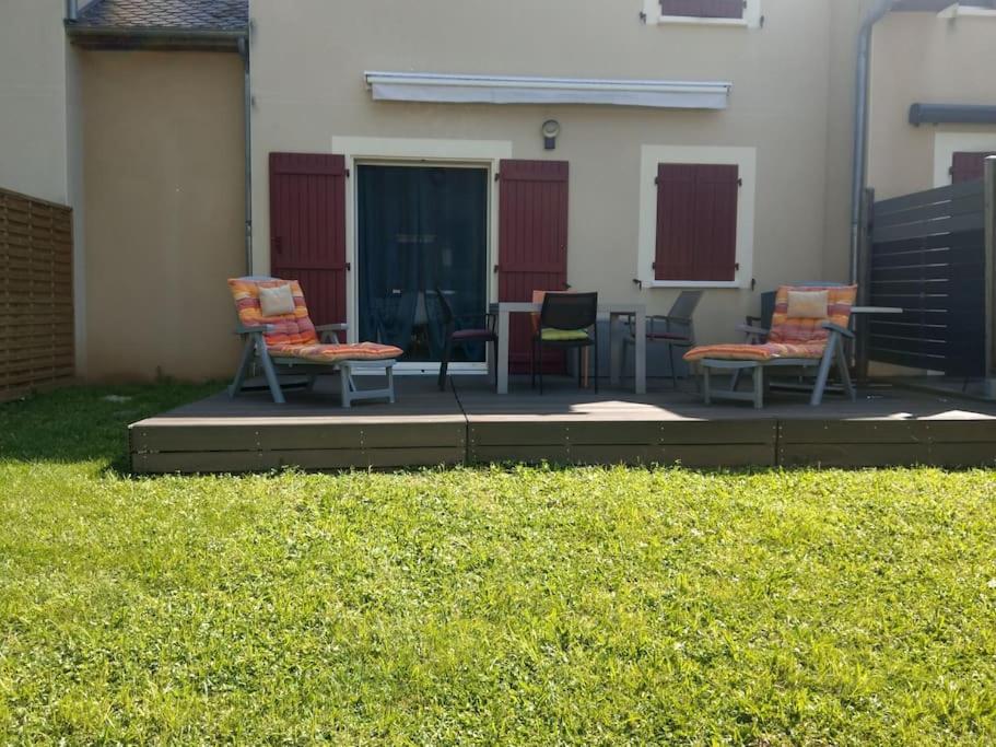 un groupe de chaises assises sur une terrasse dans l'établissement Appartement Duplex tout confort, à Pierrefiche