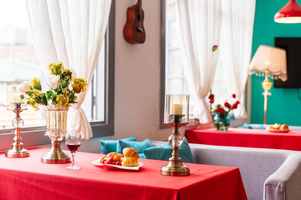 een rode tafel met een bord eten en een glas wijn bij Changsha Fuxiangyuan International Hostel in Changsha