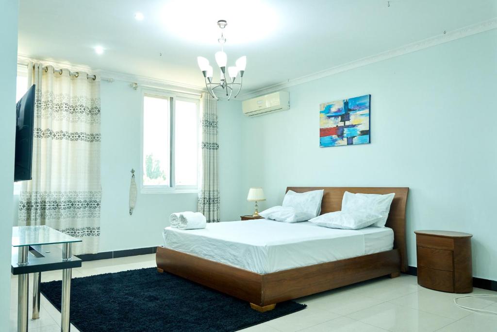 ein weißes Schlafzimmer mit einem Bett und einem Fenster in der Unterkunft Lomes cozy home Mikocheni near Beach in Daressalam