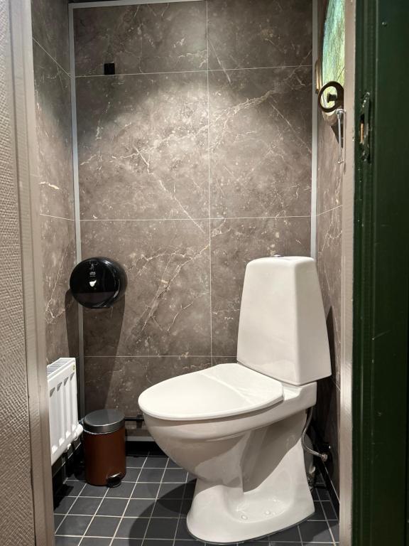 a bathroom with a toilet and a tiled wall at Den Röda Båten in Stockholm