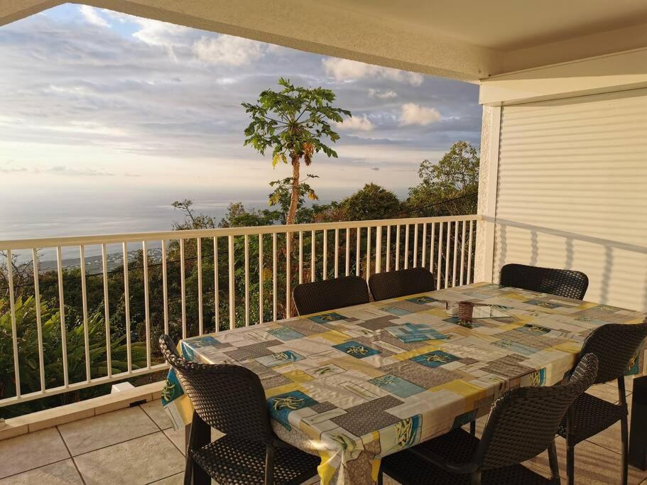 einen Tisch auf einem Balkon mit Meerblick in der Unterkunft A la belle Etoile. Appt de charme 1er ét. villa in Saint-Leu