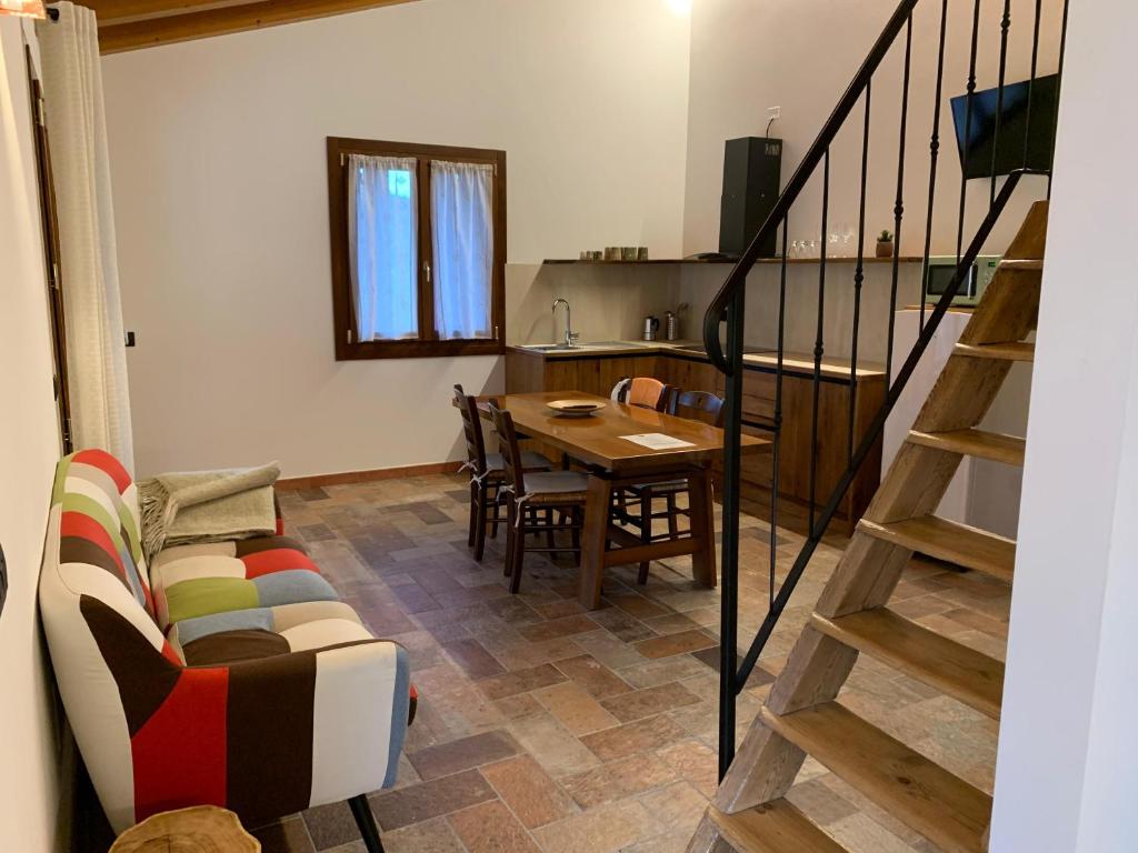 sala de estar con sofá, mesa y escaleras en Agriturismo Tamellini, en Soave