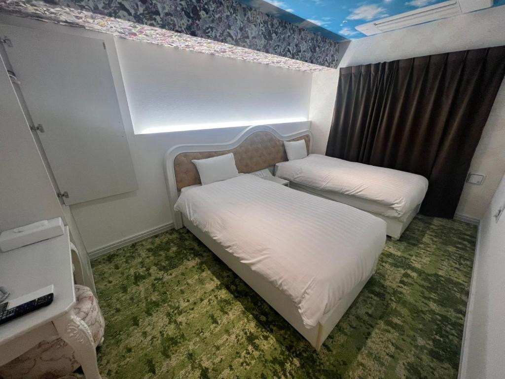 東京にあるHotaku HOTEL Akihabaraのベッド2台と窓が備わる小さな客室です。