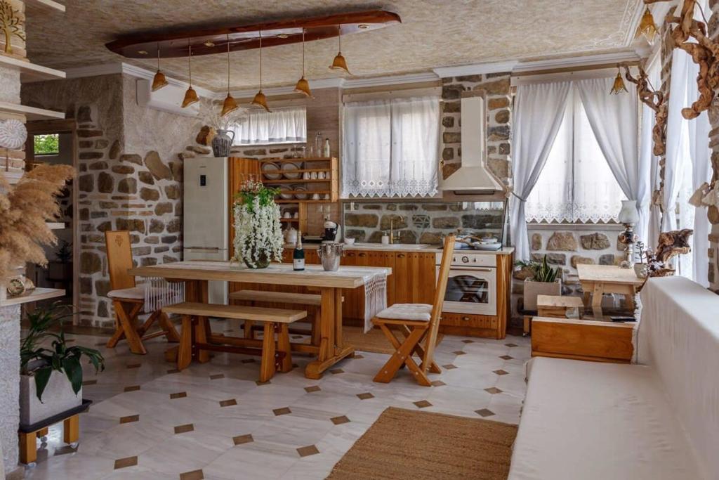 eine Küche mit einem Tisch und Stühlen sowie einem Kühlschrank in der Unterkunft Lithos Messolongi Paradise - A Luxurious Retreat in Mesolongi