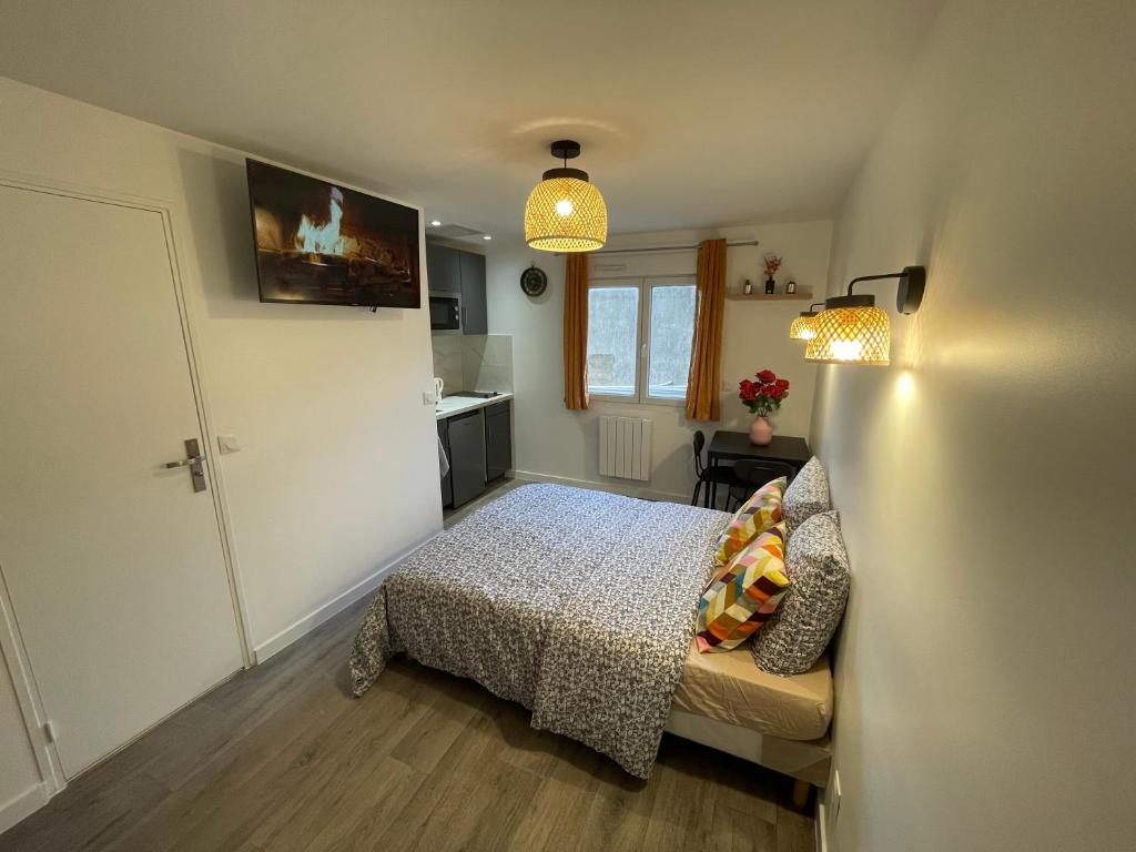 une petite chambre avec un lit et une cuisine dans l'établissement studio les 8 jasmins mignon et neuf, à Tremblay-en-France