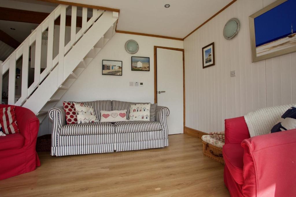 een woonkamer met twee banken en een trap bij Chalet Fortythree in Deal