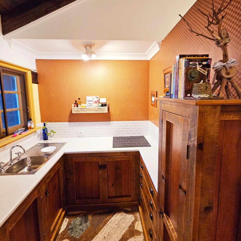 a kitchen with wooden cabinets and a sink at The Gamekeepers Spa Cottage in Tamborine Mountain in Mount Tamborine