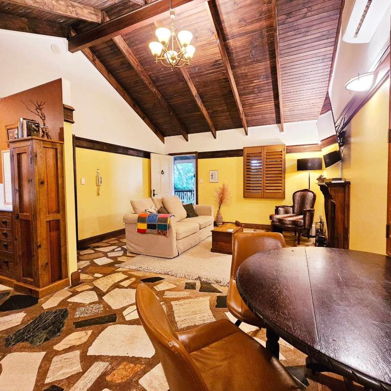 a living room with a table and a couch at The Gamekeepers Spa Cottage in Tamborine Mountain in Mount Tamborine