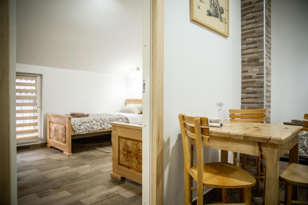 une salle à manger avec une table et une chambre dans l'établissement Jelena Apartmani, à Sombor