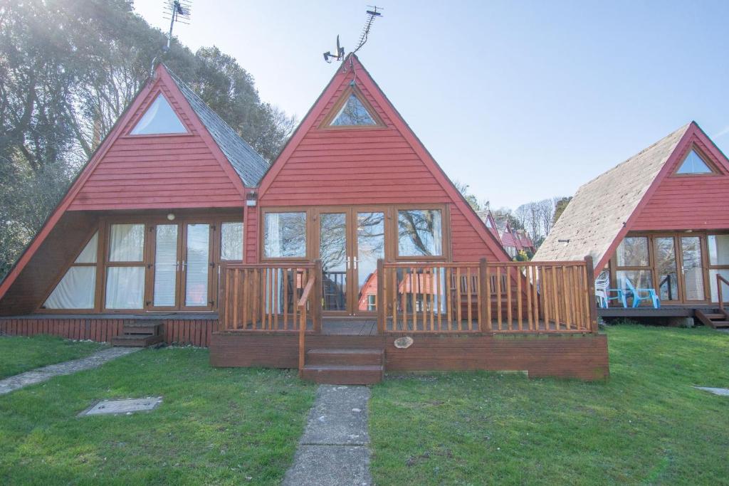 uma casa com um telhado vermelho e um alpendre em Chalet Sixtysix em Deal