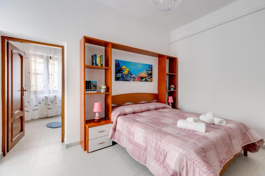 a bedroom with a bed with a wooden headboard at Casa Miriam in Oristano