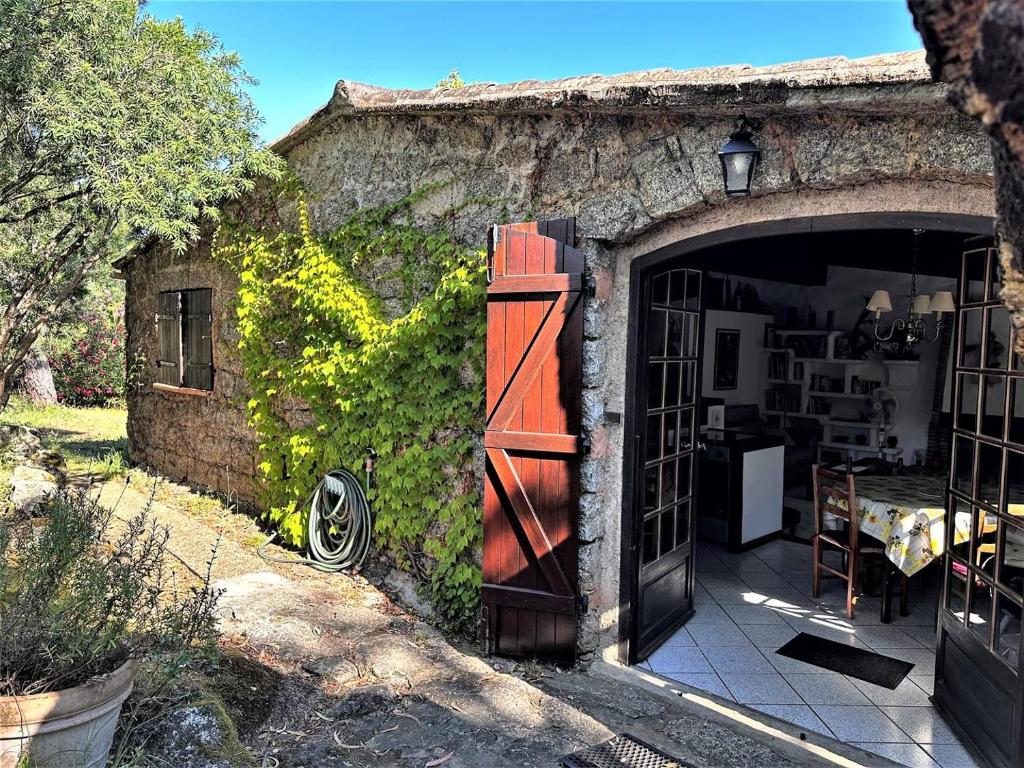 einen Eingang zu einem Steingebäude mit offener Tür in der Unterkunft Charmante maison de campagne avec piscine in Sartène