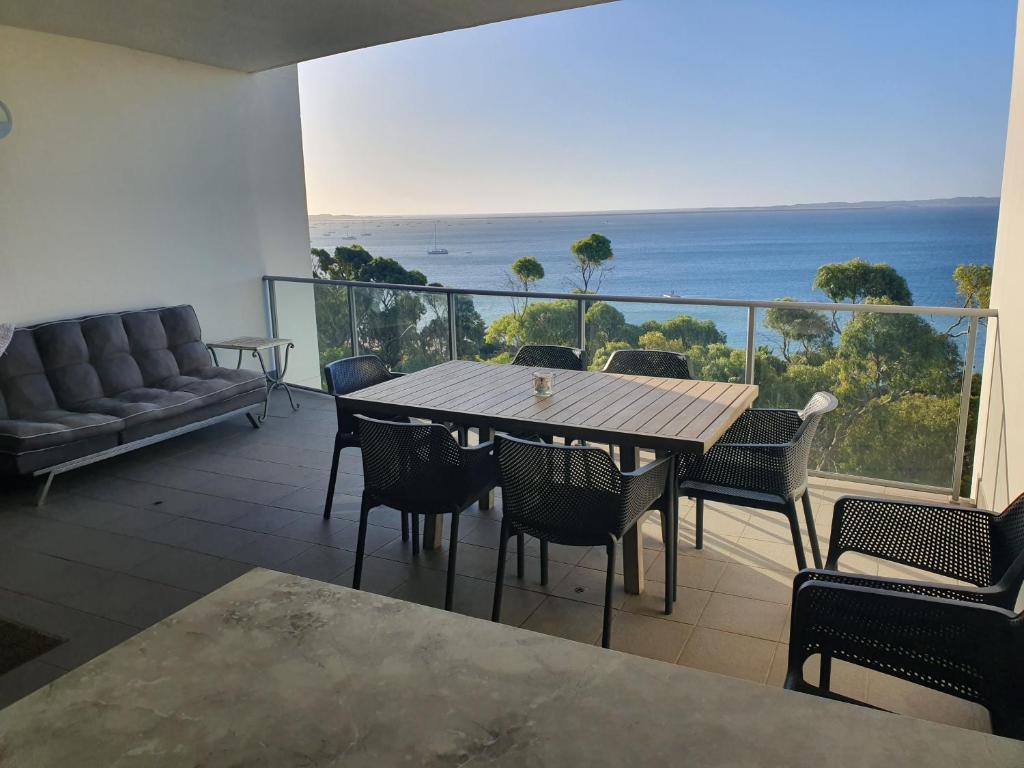 a table and chairs on a balcony with a view of the ocean at Serenity by the Sea in Rockingham