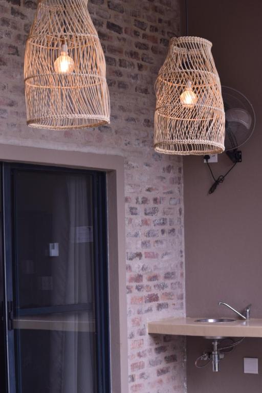 two wicker lights hanging from the ceiling in a kitchen at Hyena Den - Marloth Park in Marloth Park