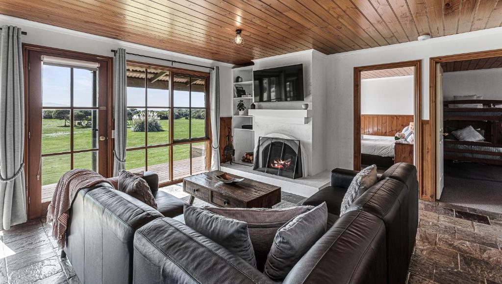 un soggiorno con divano e camino di Apollo Bay Cottages- Sabine a Marengo