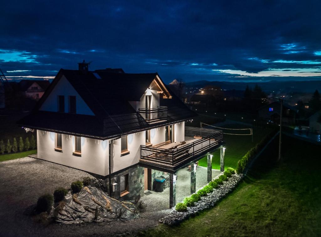 a white house with a black roof on a hill at Widokówka Koniaków in Koniaków