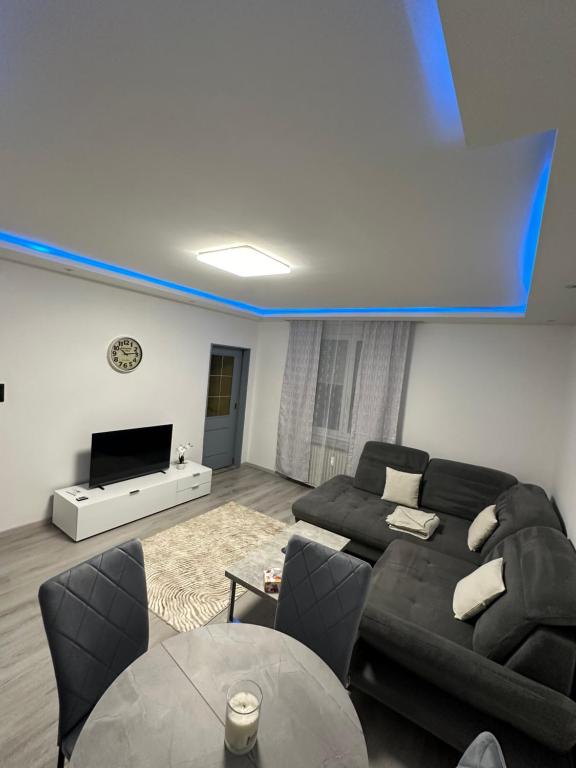 a living room with a black couch and a flat screen tv at Familien Apartment in Veitsch