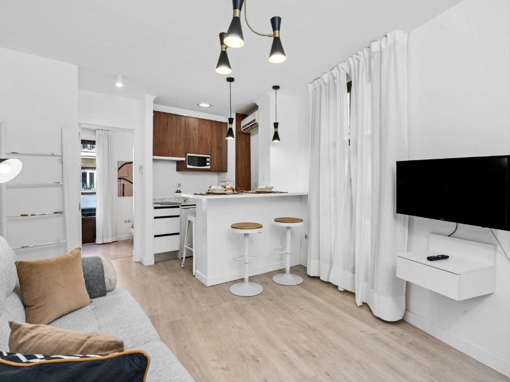 ein Wohnzimmer mit einem Sofa und einer Küche in der Unterkunft Elegant and Central Location in Granada