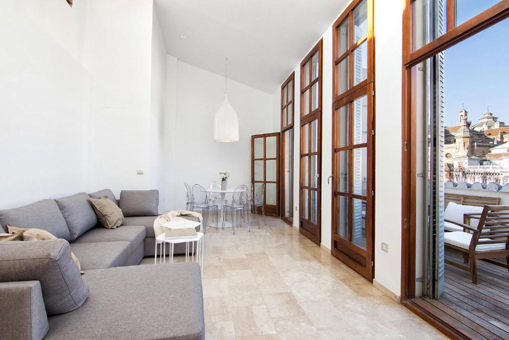 een woonkamer met een bank en een tafel bij Bibrambla penthouse over Cathedral in Granada